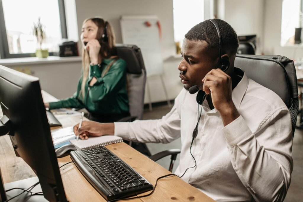 A focused team of customer service representatives working on computers and answering calls in an office